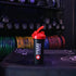 Maxi Nutrition shaker cup with red lid on a gym bench with weight rack in the background