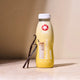 MaxShake vanilla protein shake bottle with vanilla beans on a beige background