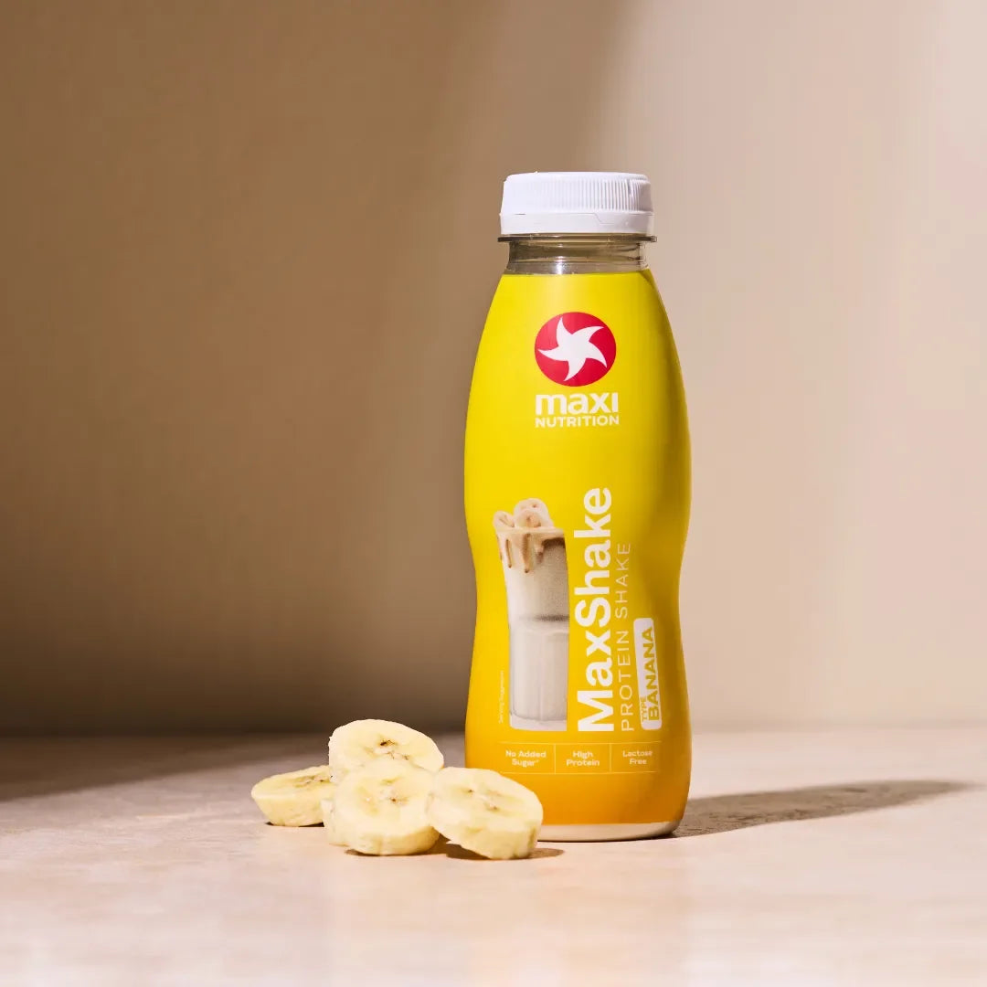 Maxi Shake protein shake bottle with banana slices on a beige background
