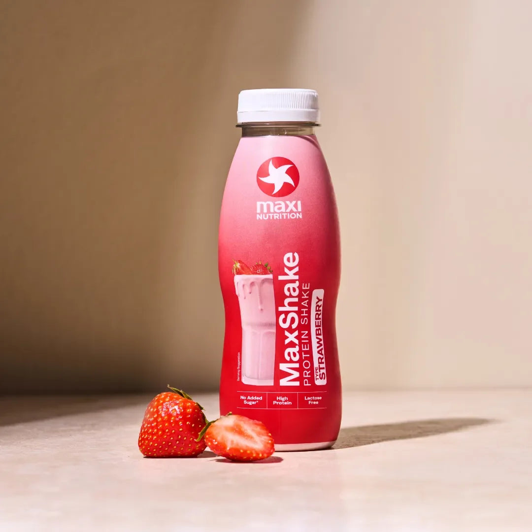 Maxi Nutrition Maxi Shake Strawberry protein shake bottle with strawberries on a beige background